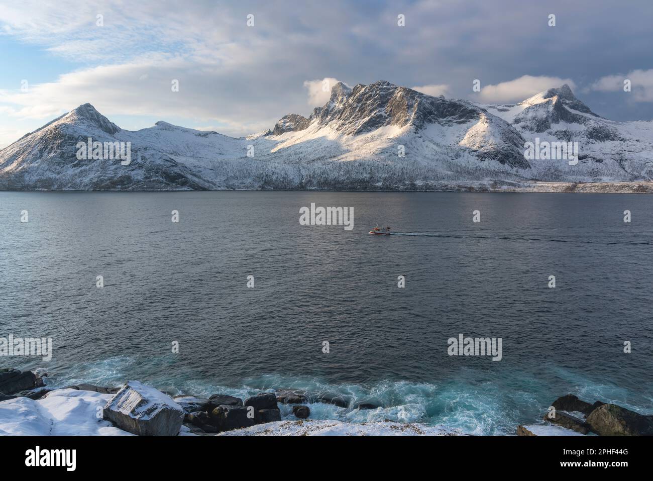 Fischer am Morgen, Schiff im Øyfjorden, mit den schneebedeckten Bergen von Senja, genannt Segla, Kongan und Skultran im Hintergrund. Norwegen Stock Photo