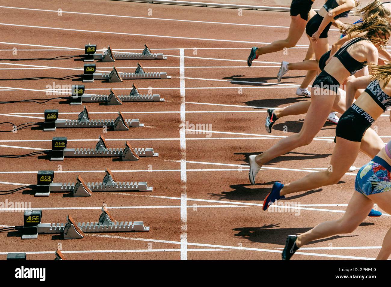female runners athletes in Nike spikes start race running from starting