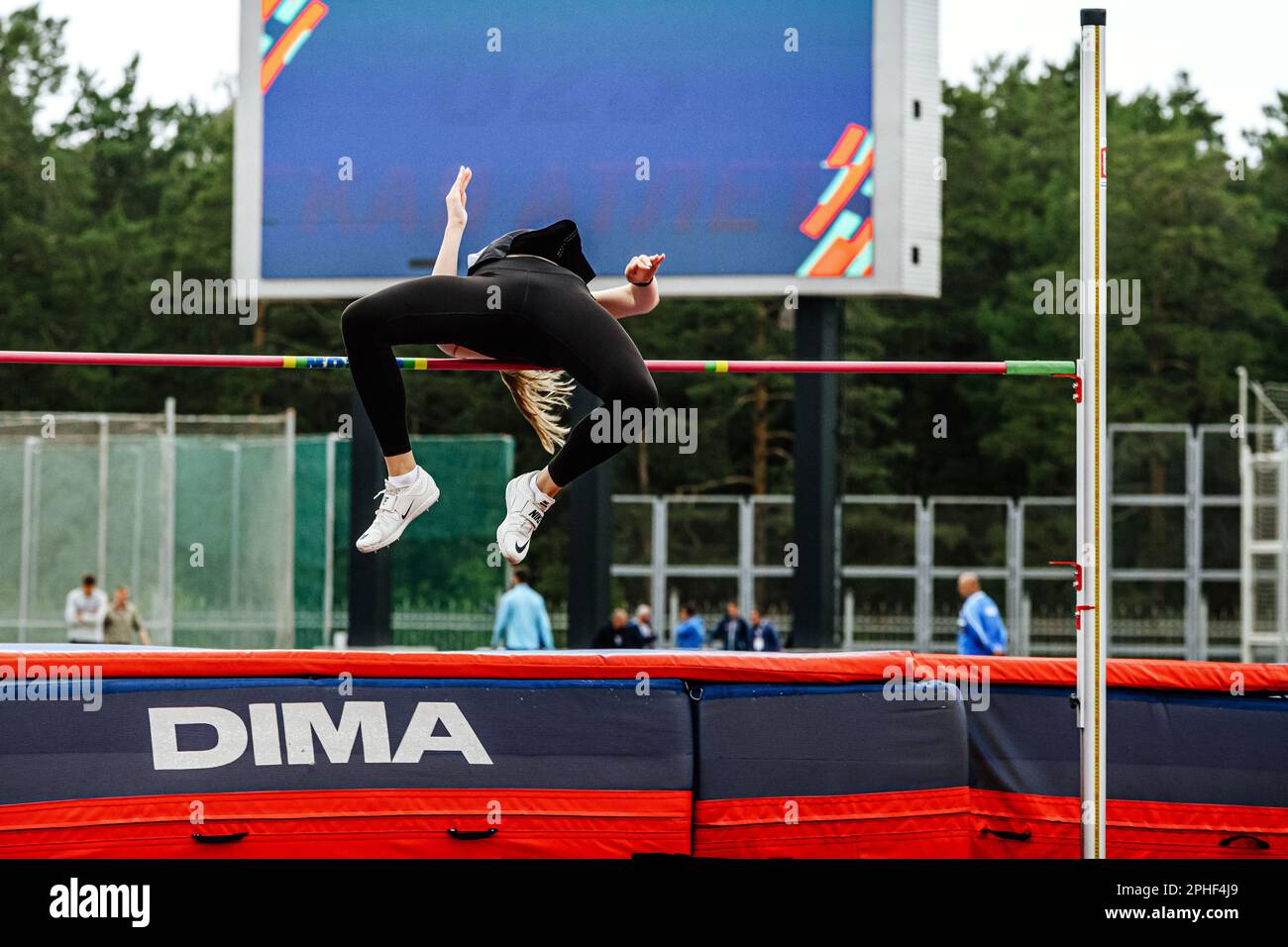 female athlete high jump method fosbury flop, high jump landing mat Dima sport, editorial photo Stock Photo