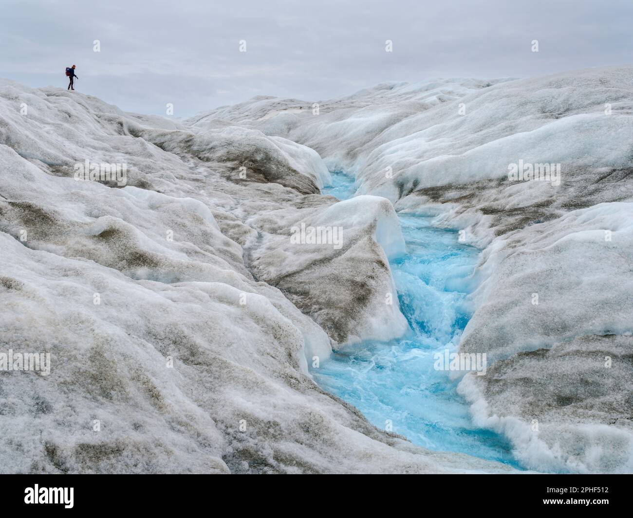 Tourists hiking on the ice. The brown sediment on the ice is created by ...