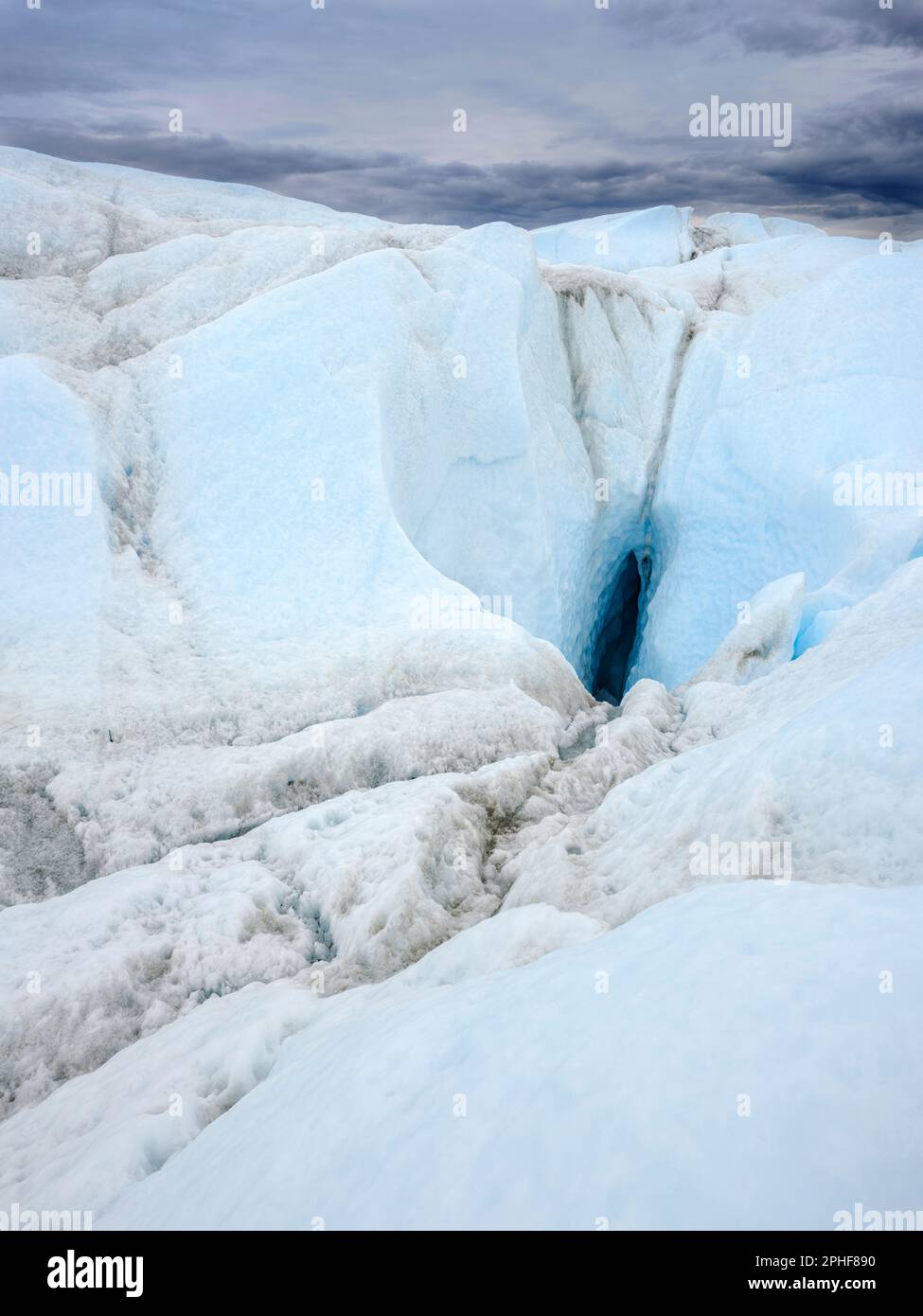 Drainage system with moulin on the surface of the ice sheet. The brown ...