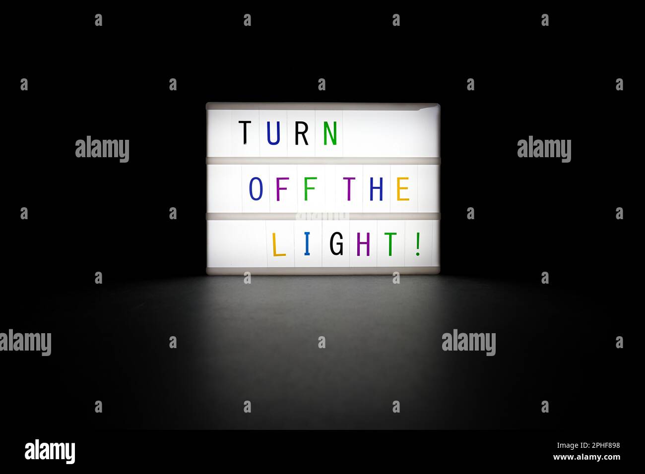Bright shining "Turn off the lights" neon sign in the dark on black