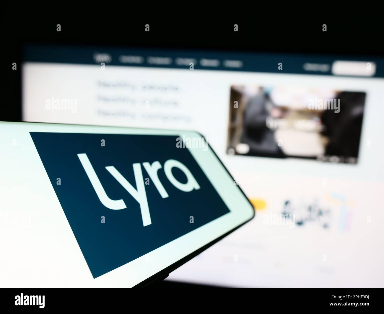 Cellphone with logo of American mental health company Lyra Health Inc. on screen in front of business website. Focus on left of phone display. Stock Photo