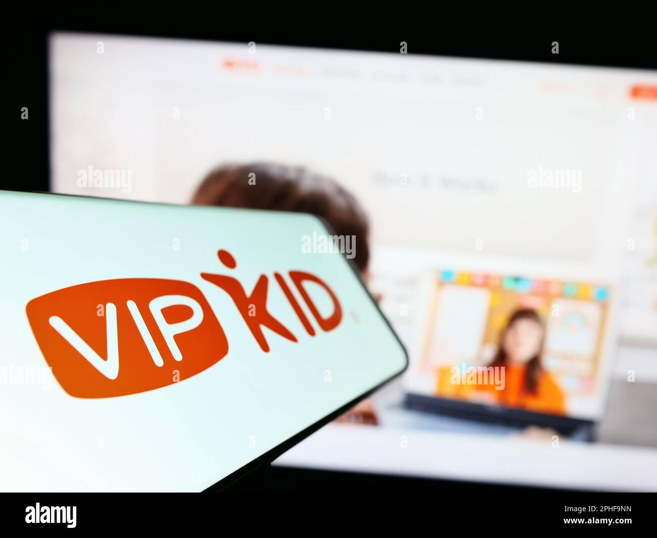 Smartphone with logo of e-learning company VIPKid on screen in front of business website. Focus on left of phone display. Stock Photo