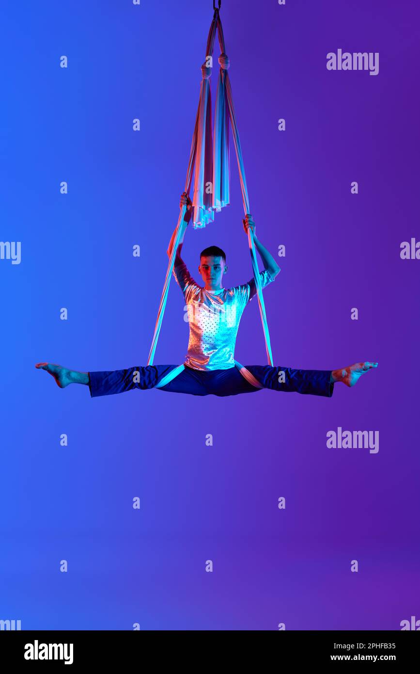 Professional male aerial gymnast training with aerial ribbons against