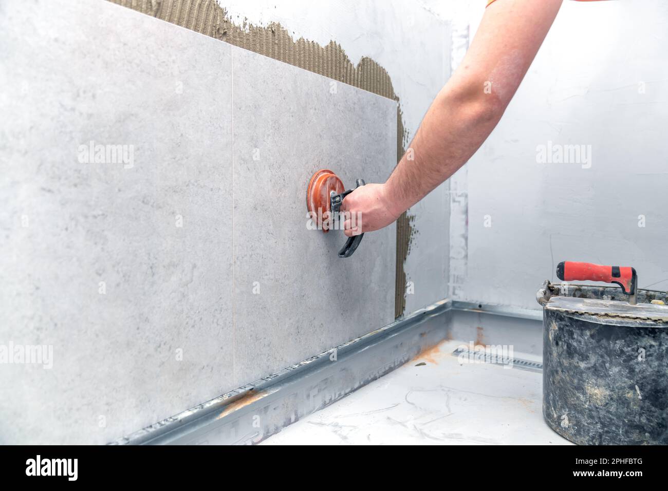 craftsman tiling the room with large format tiling Stock Photo