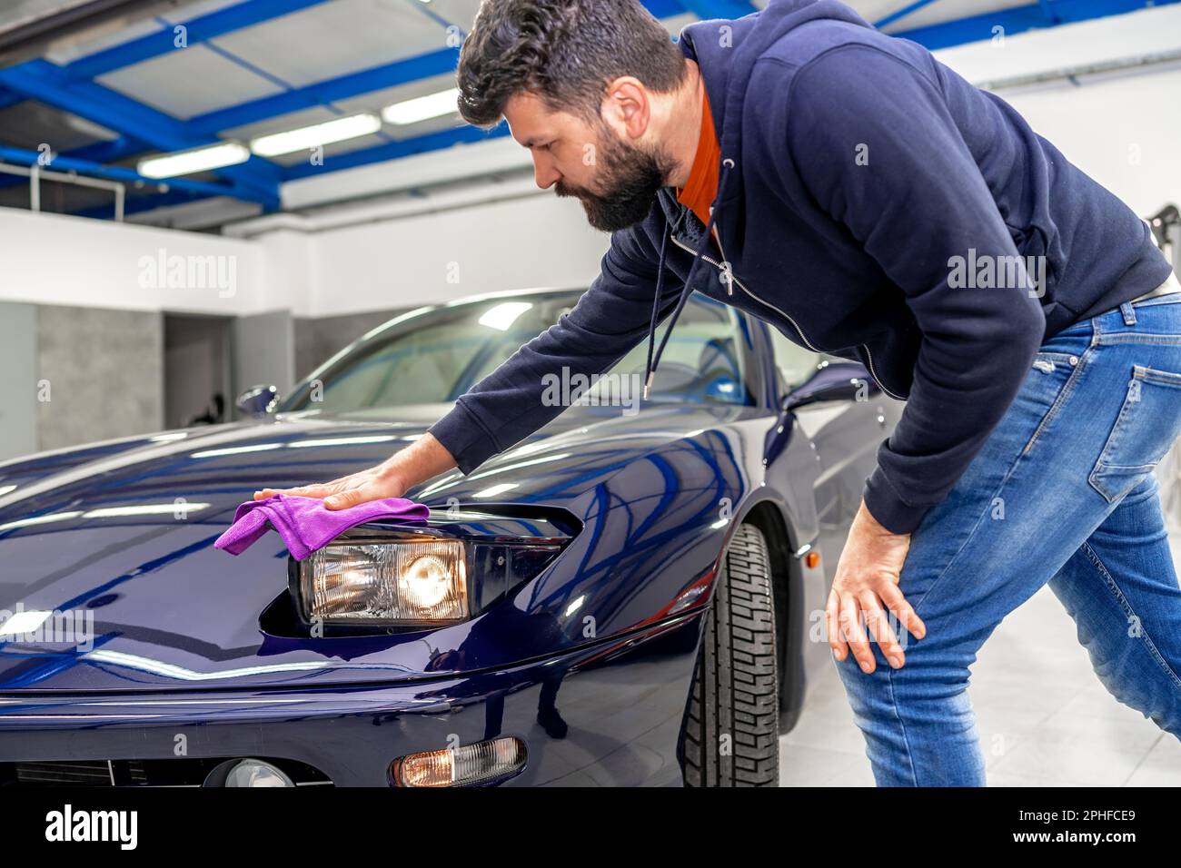 detailing and polishing the body of a luxury sports car using a micro fiber Stock Photo