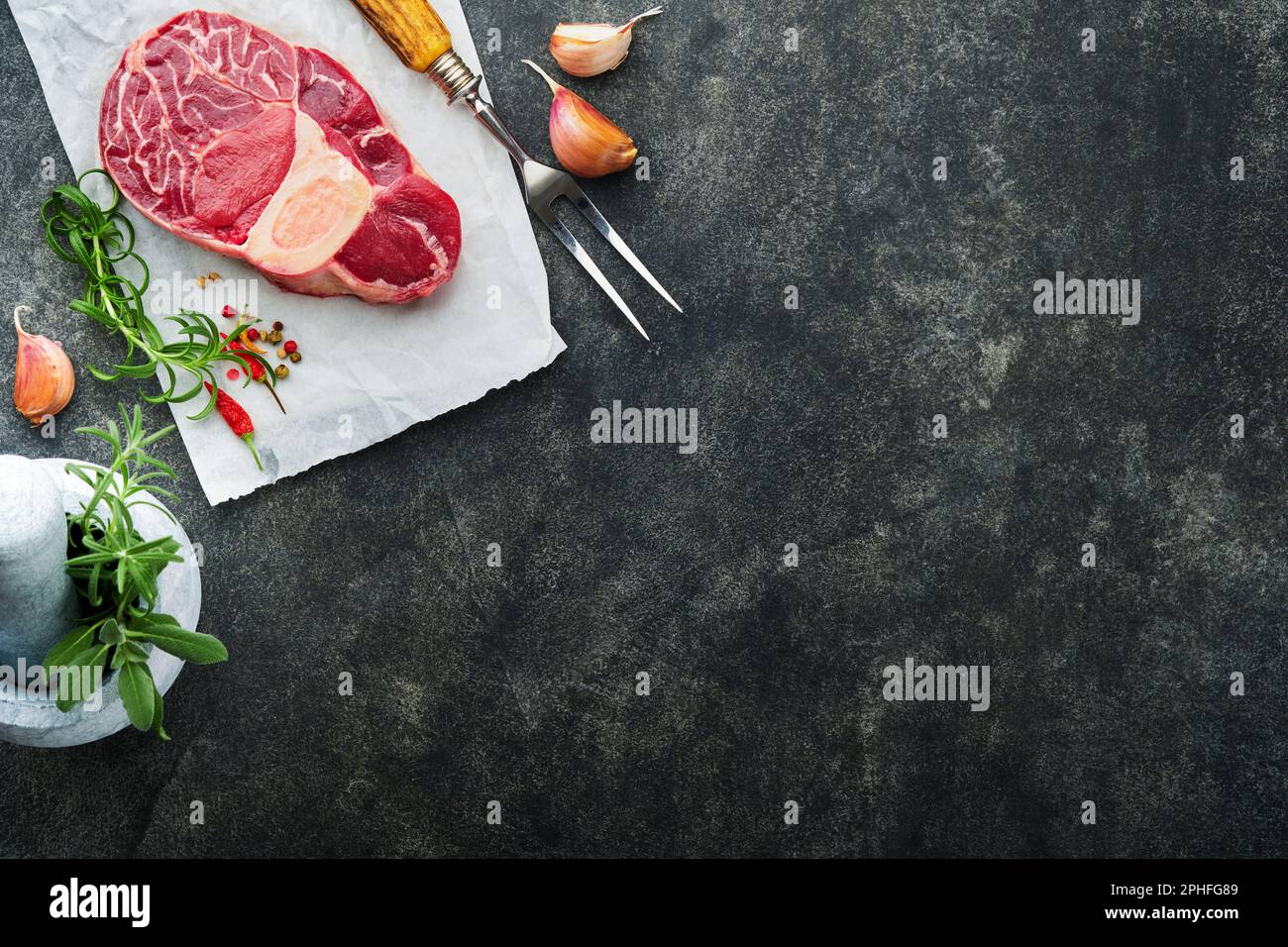 Osso Buco raw steak meat. Barbecue meat. Raw fresh cross cut veal shank and seasonings pepper, rosemary, thyme and salt on dark background. Beef Leg S Stock Photo