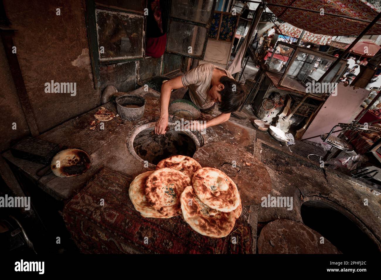 An old vendor selling baked naan on the old street of Kashgar, the cakes are full of fragrance Stock Photo