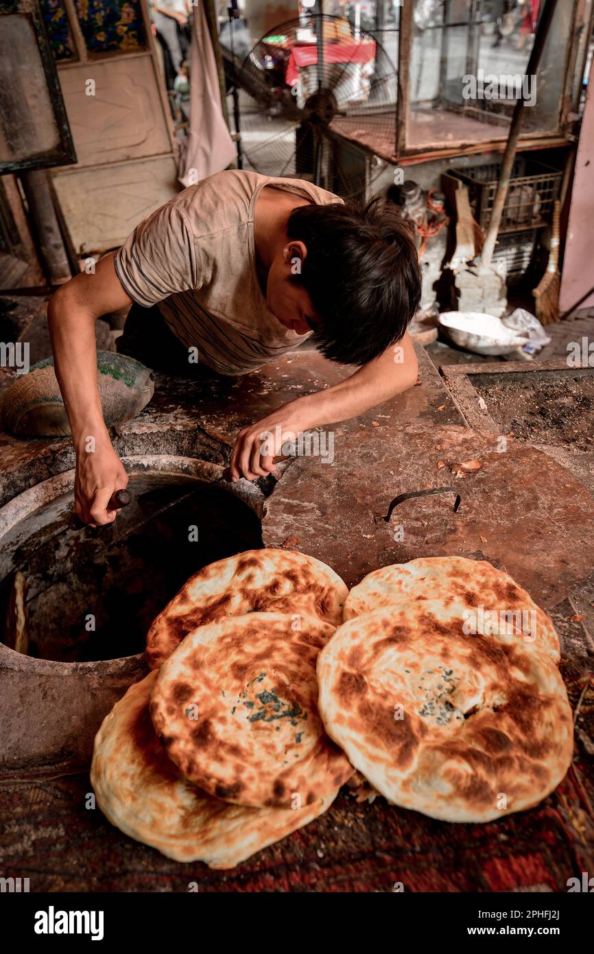 An old vendor selling baked naan on the old street of Kashgar, the cakes are full of fragrance Stock Photo