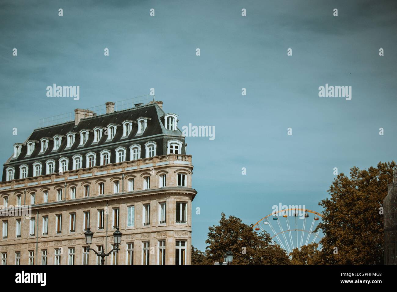 Bordeaux, Paris. October 5, 2022 A typical French apartment house exterior, Ferris wheel against a blue sky. Classic old architecture. Traveling throu Stock Photo