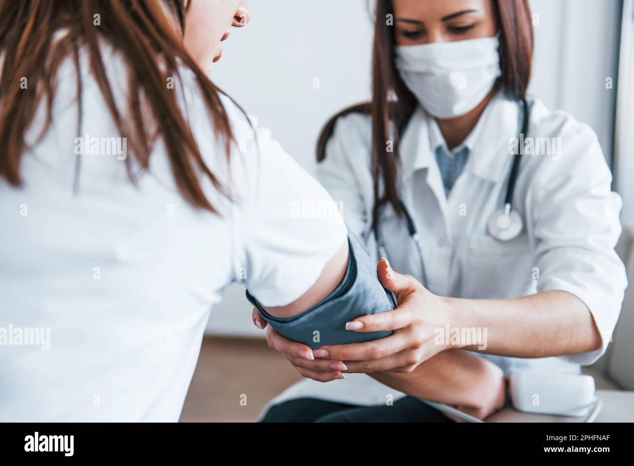 Measuring blood pressure. Young woman have a visit with female doctor ...