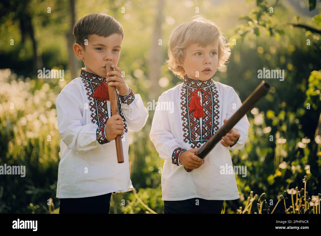 Little brothers boys playing woodwind wooden flute ukrainian sopilka