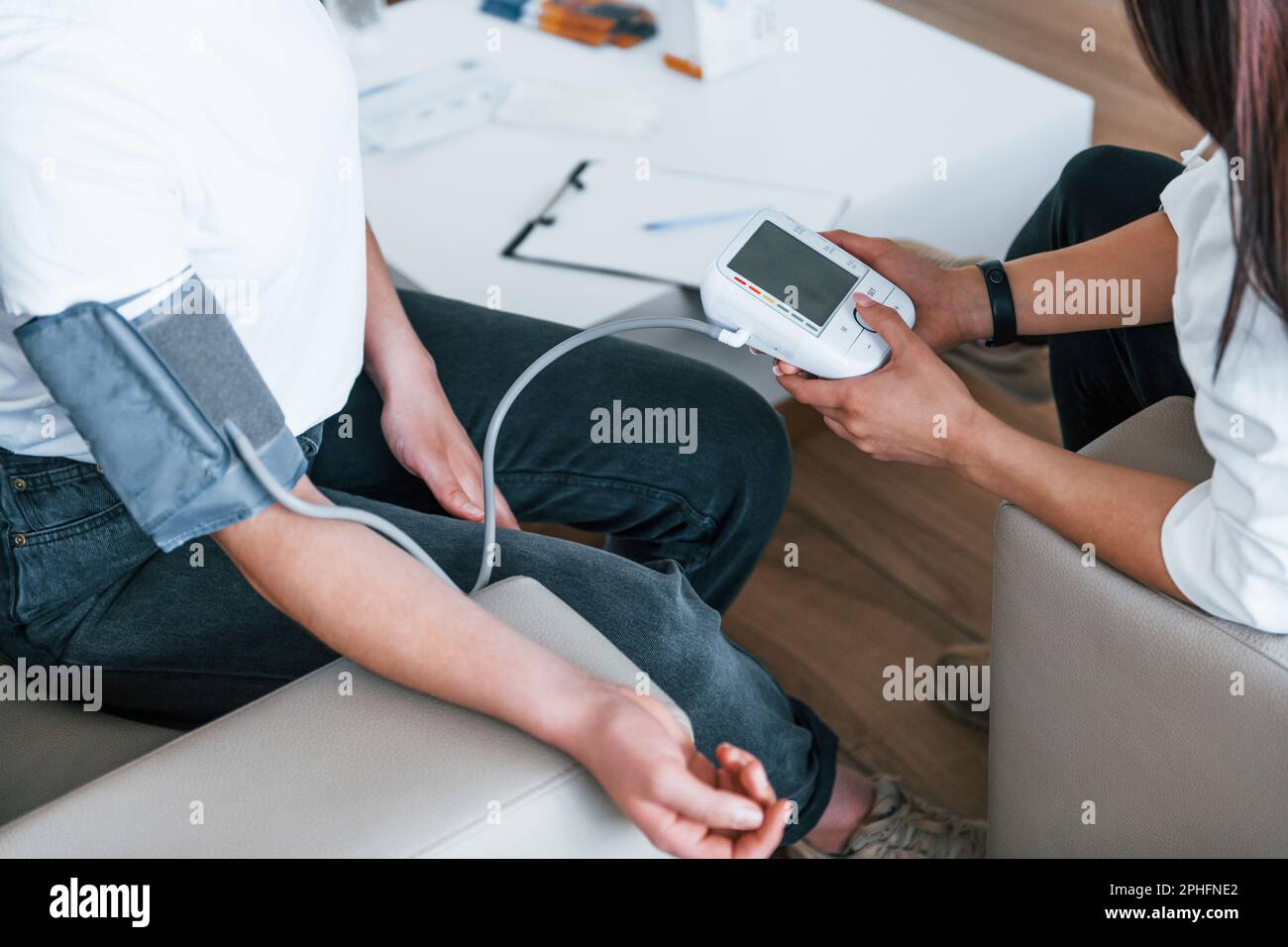 Measuring blood pressure. Young woman have a visit with female doctor ...