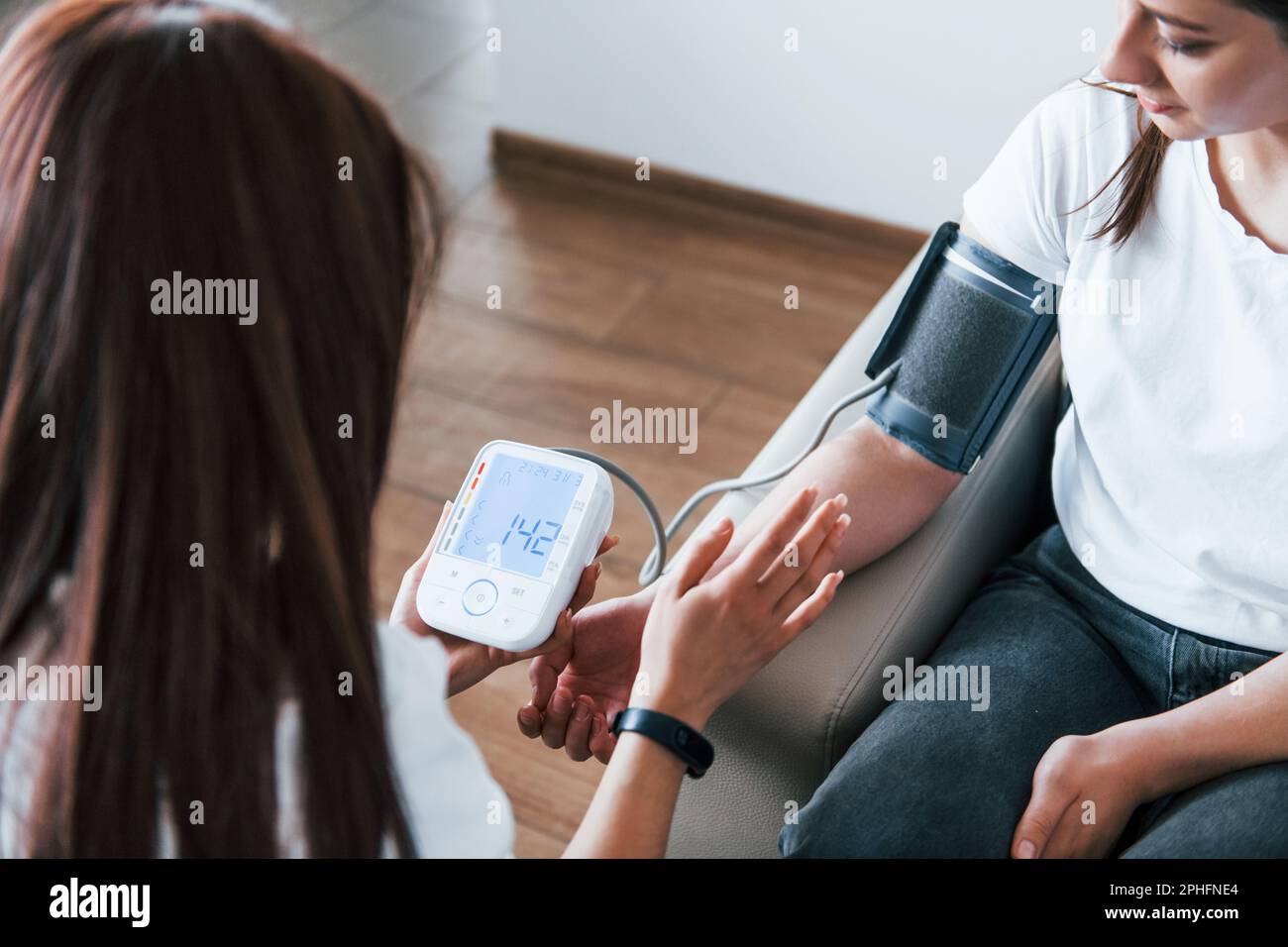 Measuring blood pressure. Young woman have a visit with female doctor ...