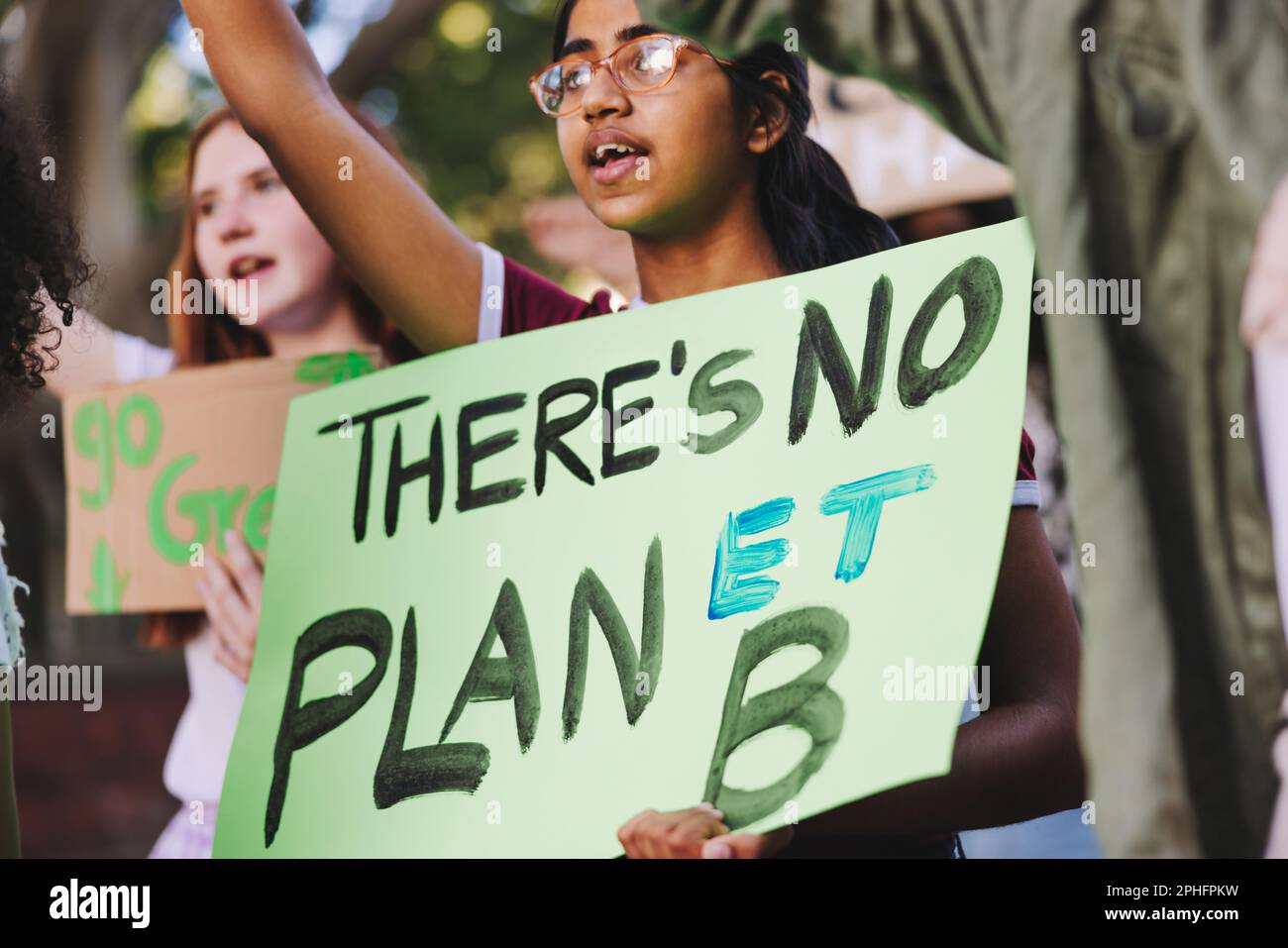 Teenage activists standing up against climate change. Group of multiethnic youth activists marching against global warming and pollution. Diverse youn Stock Photo