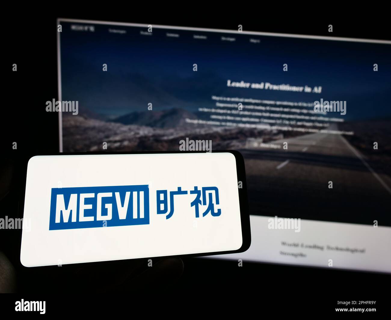 Person holding cellphone with logo of Chinese company Megvii Technology Limited on screen in front of business webpage. Focus on phone display. Stock Photo