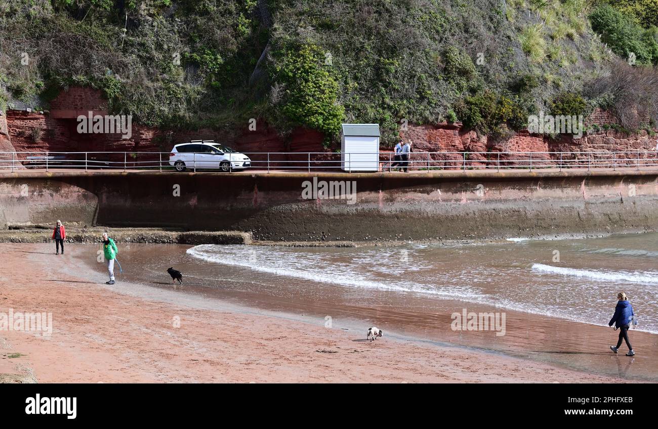 A beach hut and car moving along the narrow promenade at Goodrington ...