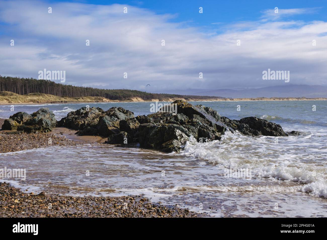 Rocks and surf at high tide on Newborough beach from Llanddwyn Island end. Newborough, Isle of Anglesey, Wales, UK, Britain, Europe Stock Photo
