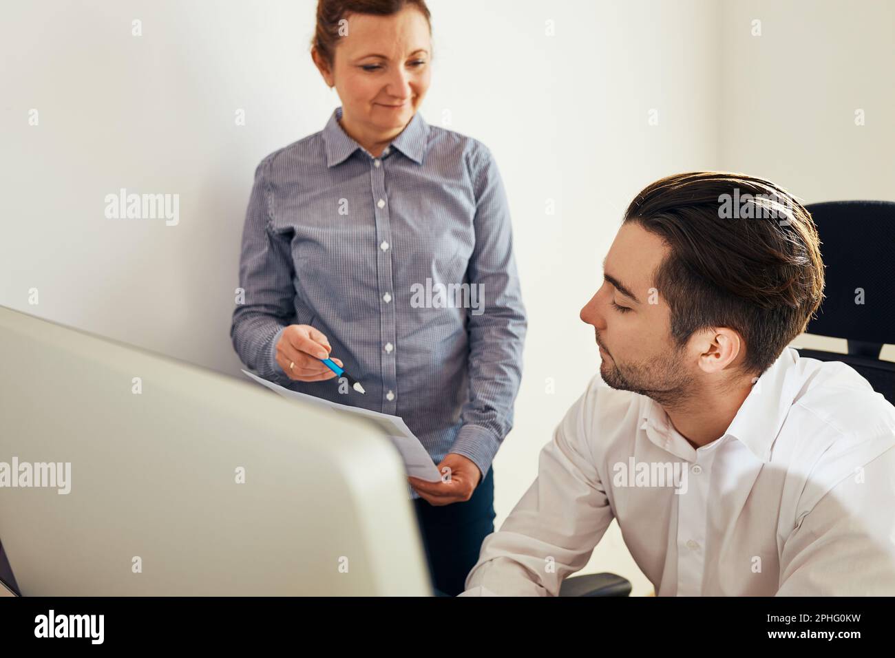 Business colleagues discussing financial data working together in office. People entrepreneurs working with charts and tables on computer. Two people Stock Photo