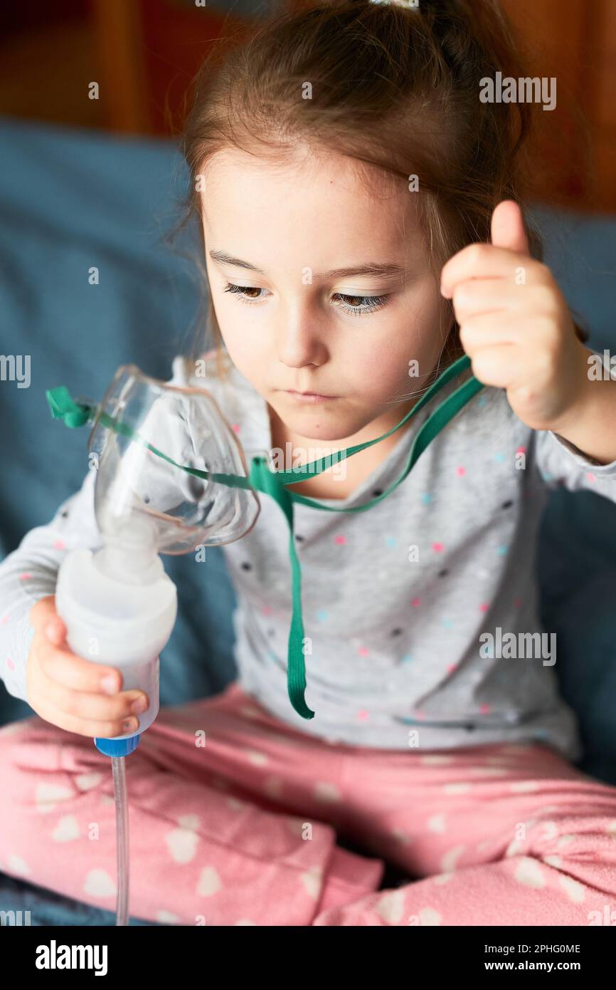 Sick little girl having medical inhalation treatment with nebuliser