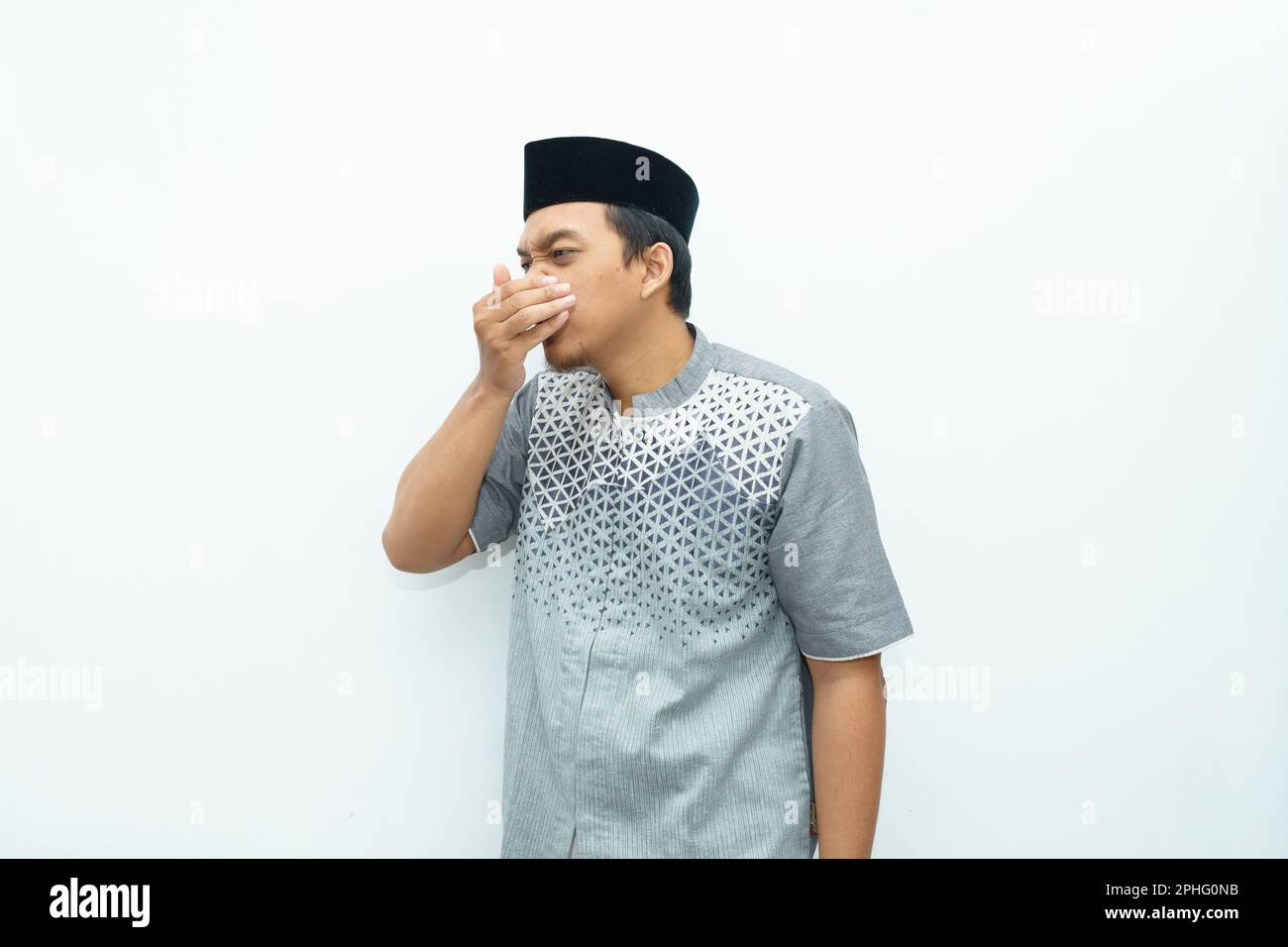 Portrait of Asian Indonesian Muslim man smells the mouth during Ramadan