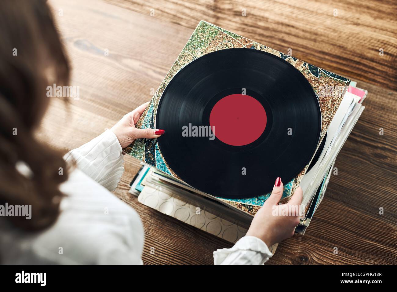 Playing vinyl records. Listening to music from vinyl record player. Retro  and vintage music style. Woman holding analog LP record album. Stack of old  Stock Photo - Alamy