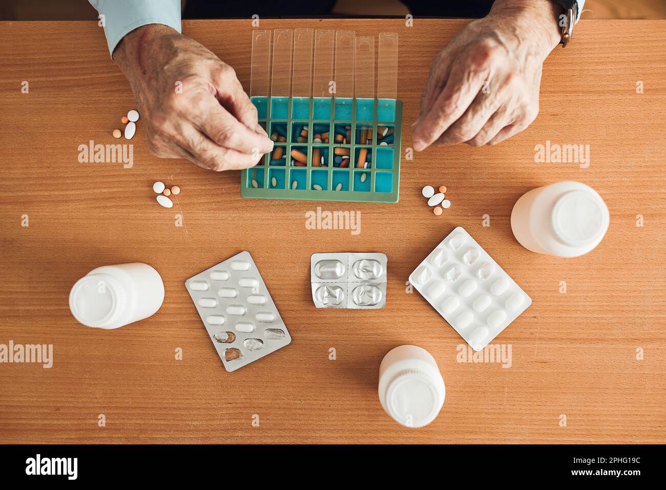 Senior man organizing his medication into pill dispenser. Senior man