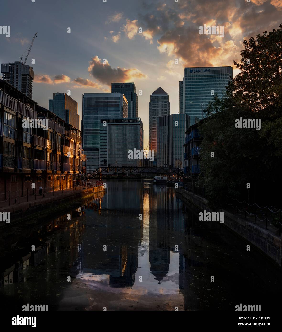 Canary Wharf at dusk, looking across Blackwall Basin from near the River Themes, the towers reflected in the water. Stock Photo
