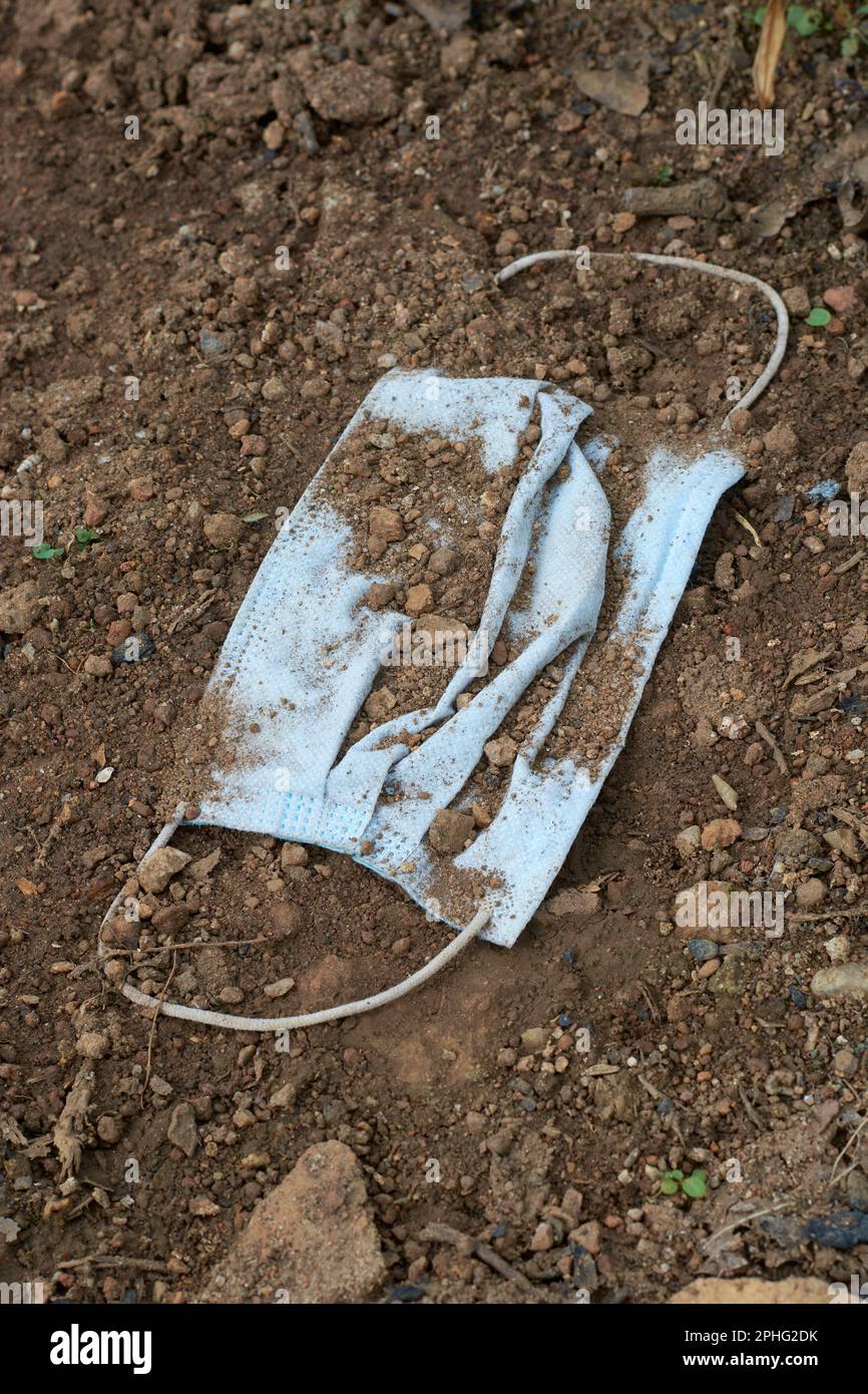 used surgical face mask thrown away on the ground, disposable mask