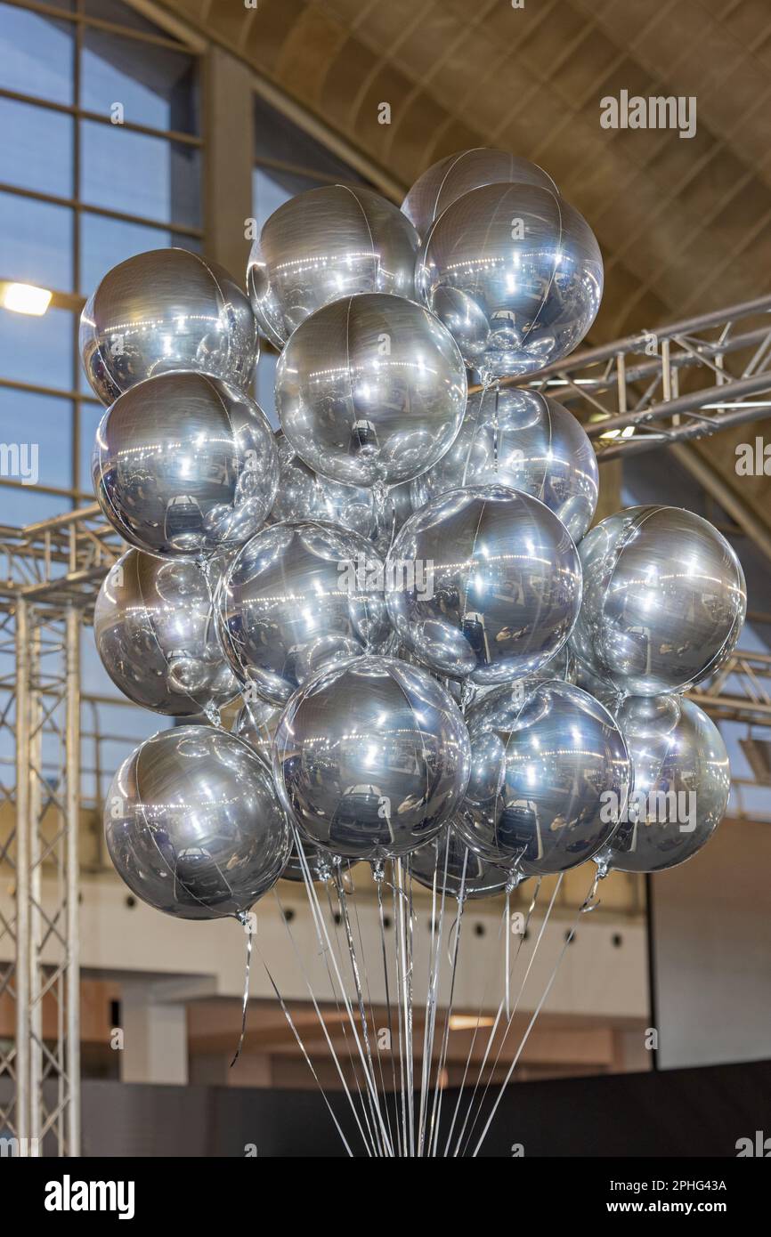 Cluster of Helium Filled Metallic Foil Silver Balloons in Hall Stock Photo