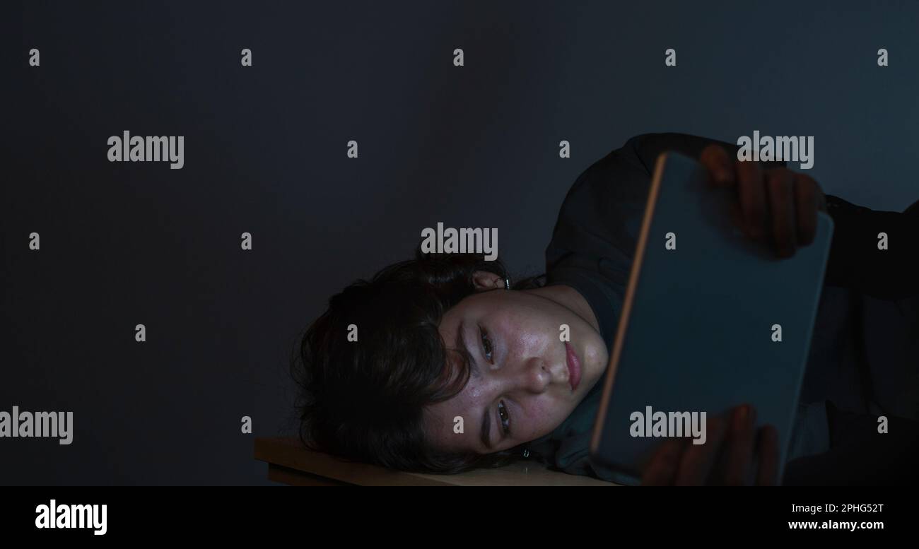 A teenage girl surfs the with a tablet or electronic device in