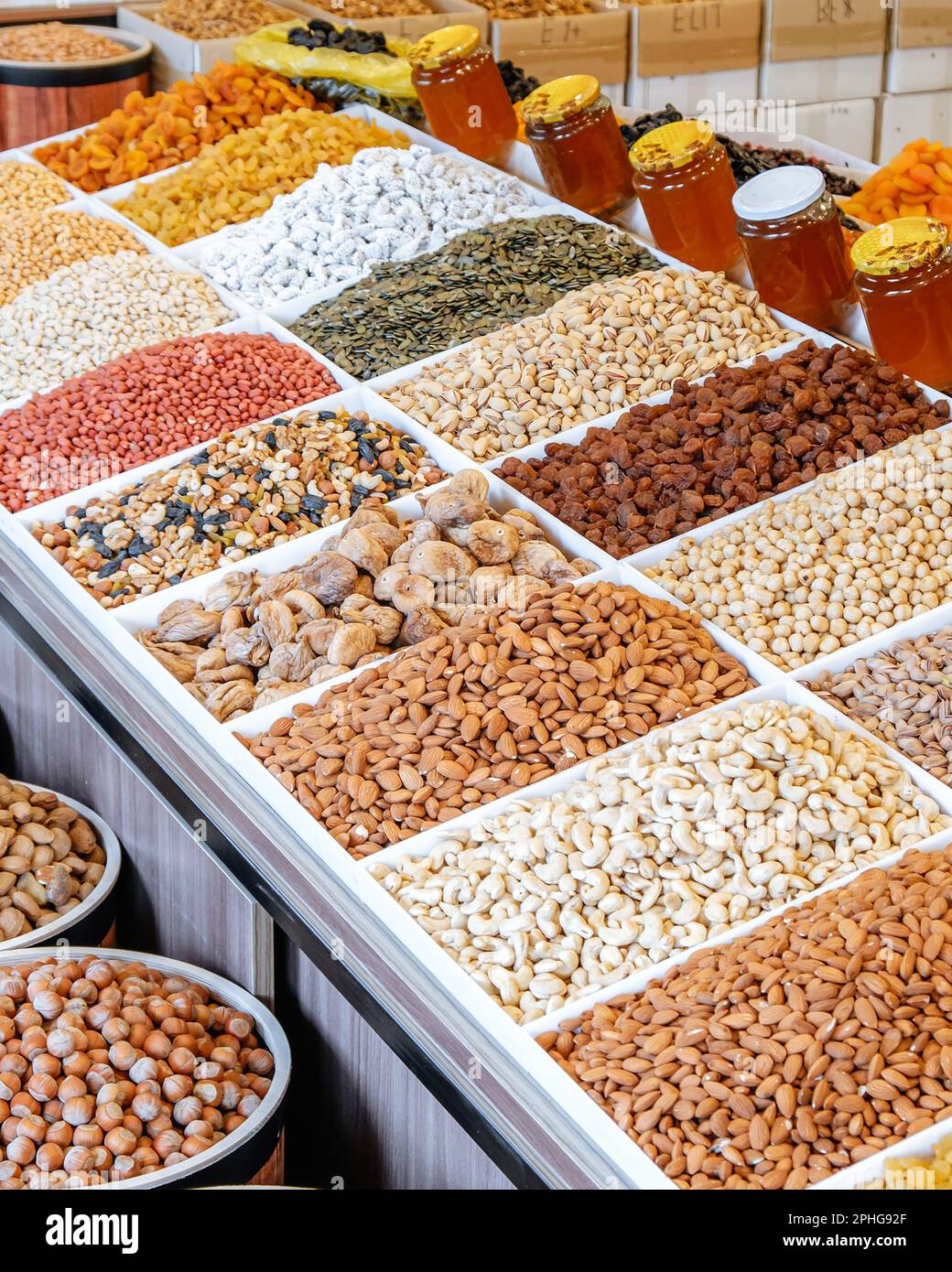 A vertical shot of a marketplace with piles of nuts and dried fruits Stock Photo