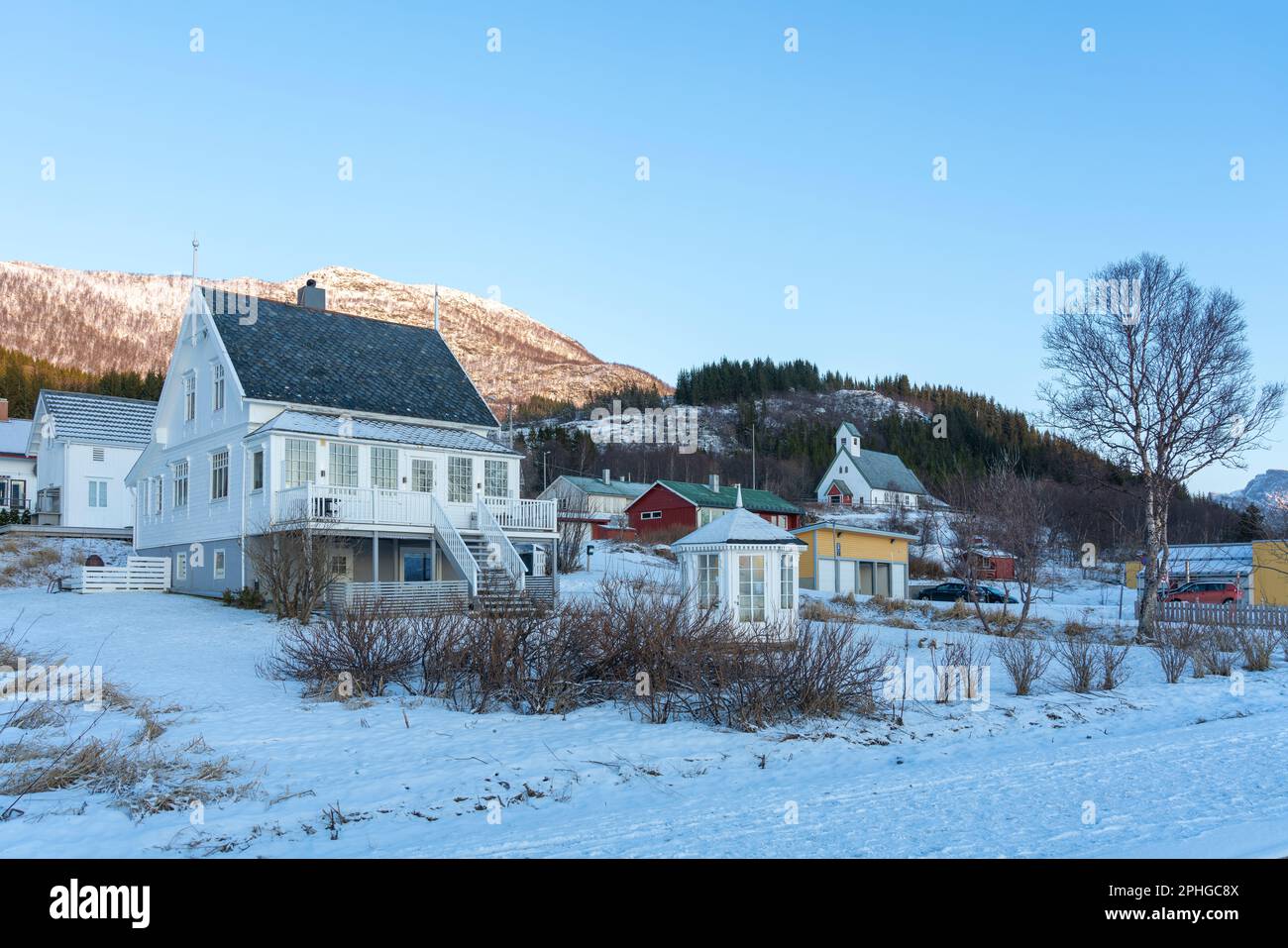 Weißes Haus nahe dem Strand in Bøvær, Senja, Norwegen. Schönes skandinavisches Wohnhaus am Abend bei Sonnenuntergang. Auf dem Weg zum Aussichtspunkt Stock Photo