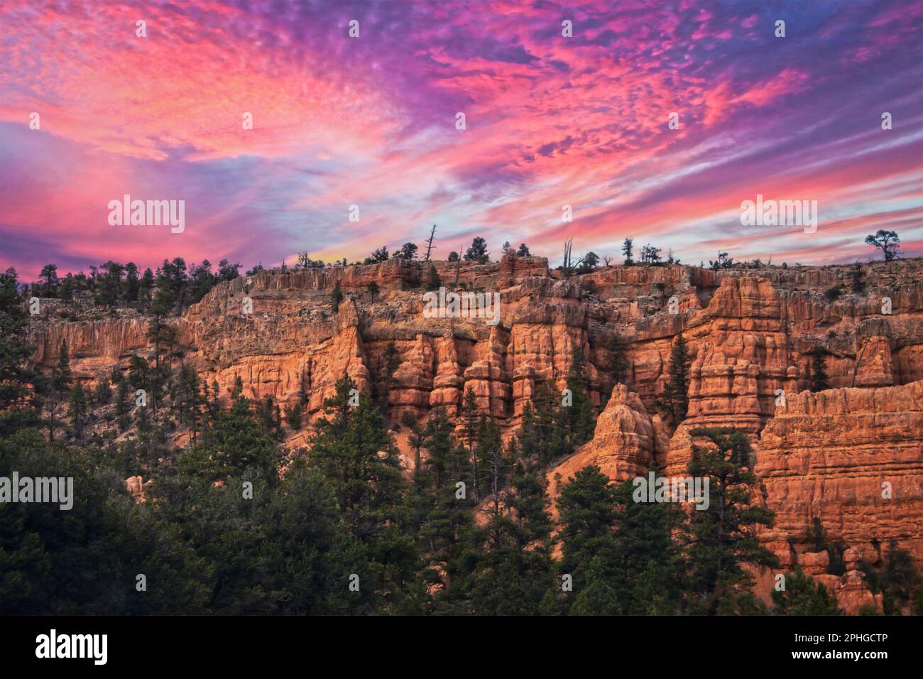 Red Rock Canyon in Dixie National Forest in Utah near Bryce - hoodoos forming from cliffs against brilliant sunset sky Stock Photo