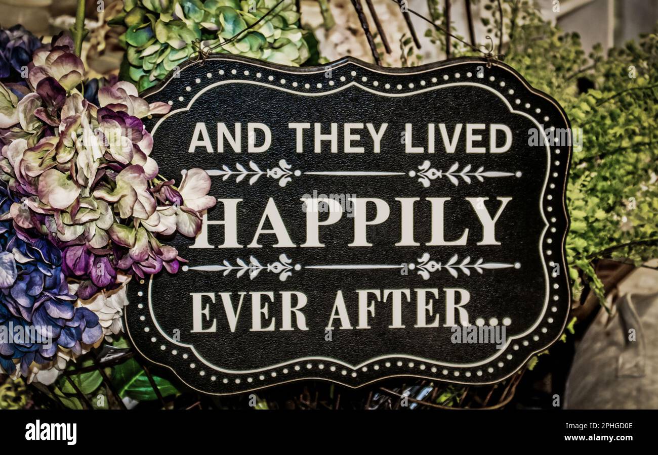 Sign saying And they Lived Happily Ever After surrounded by hydrangeas and ferns - Wedding Stock Photo
