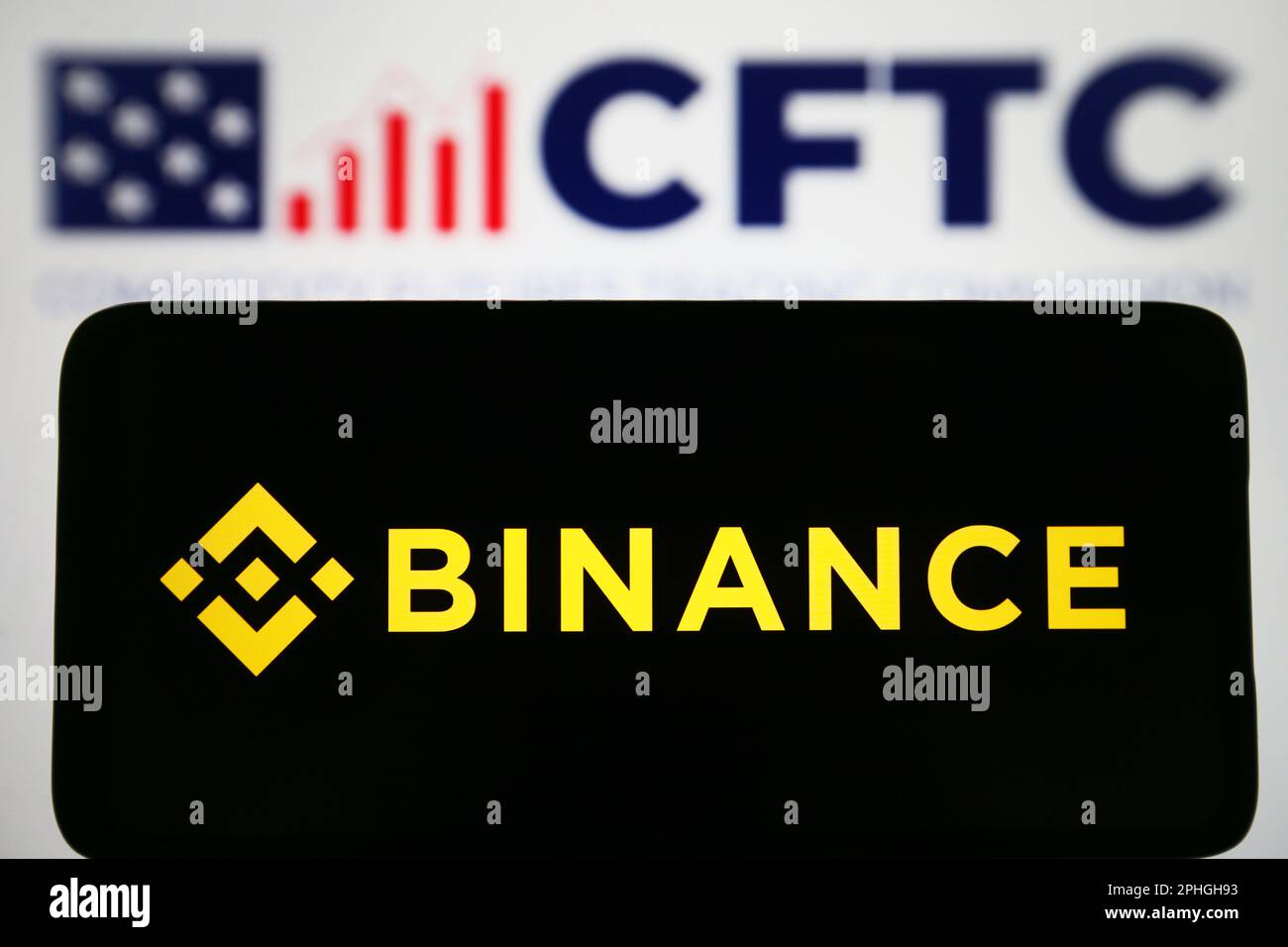 In this photo illustration, Binance logo is seen displayed on a smartphone and Commodity Futures Trading Commission (CFTC) logo on a pc screen. Stock Photo