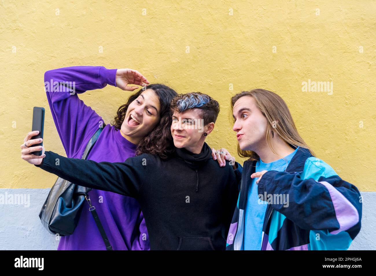 Young diverse friends taking selfies with a mobile phone outdoors. Stock Photo