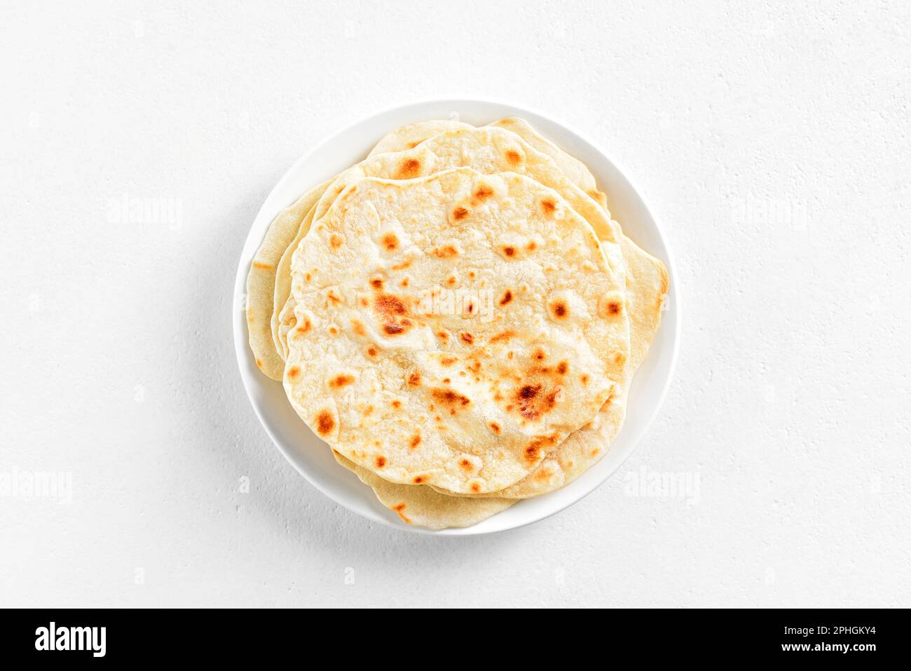Wheat flat bread on plate over white stone background with copy space. Top view, flat lay Stock Photo