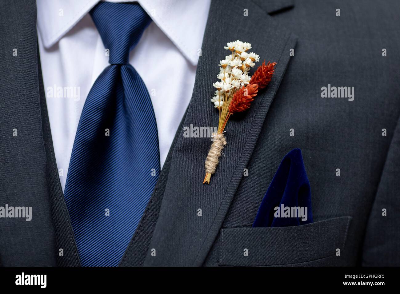 Boutonniere, tie, and handkerchief detail shot on the suit of a groom or groomsman. Stock Photo