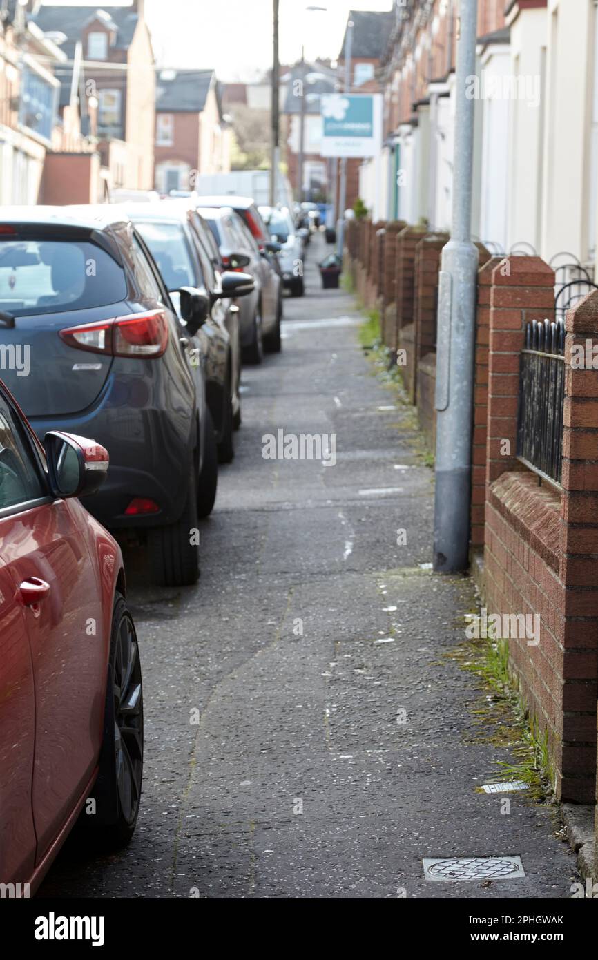cars parked on pavement making footpath narrow on residential street in city area of strandtown