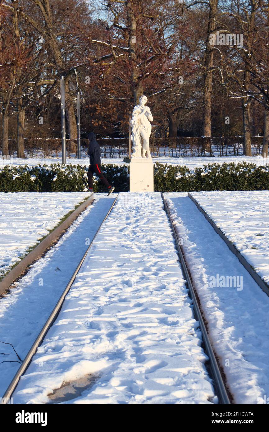 Karlsruhe, Germany - February 12, 2021: White statue on the grounds of Karlsruhe Palace on a sunny winter day with snow on the ground in Germany. Stock Photo