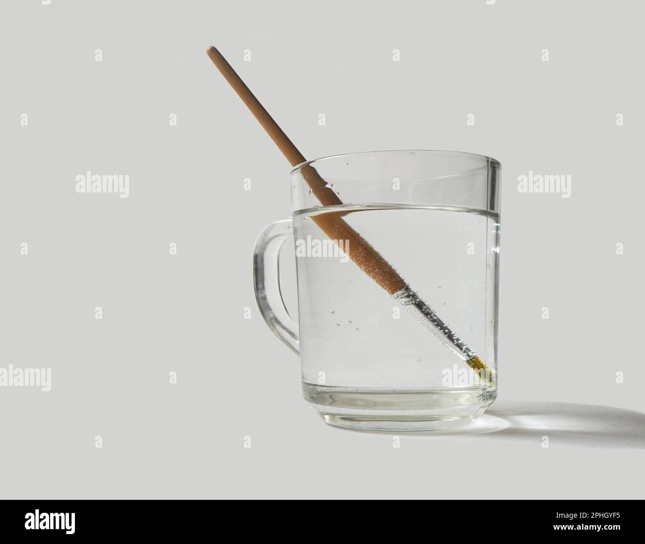 Light refraction. Refraction of light. Paint brush inside a glass of water, Stock Photo