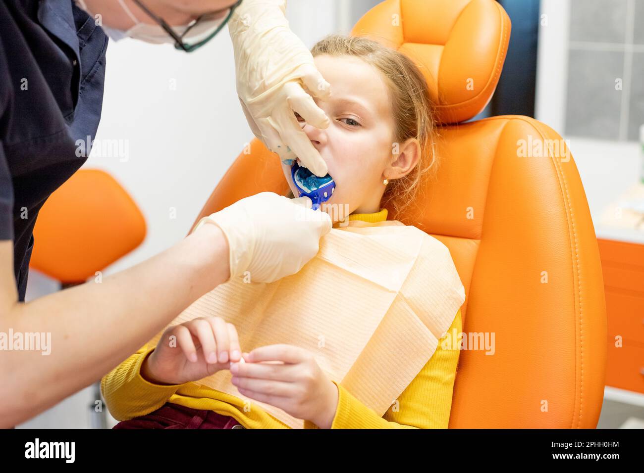 Dentist examining a patient's teeth using dental equipment impression spoon in dentistry office.Child during orthodontist visit and oral cavity check Stock Photo