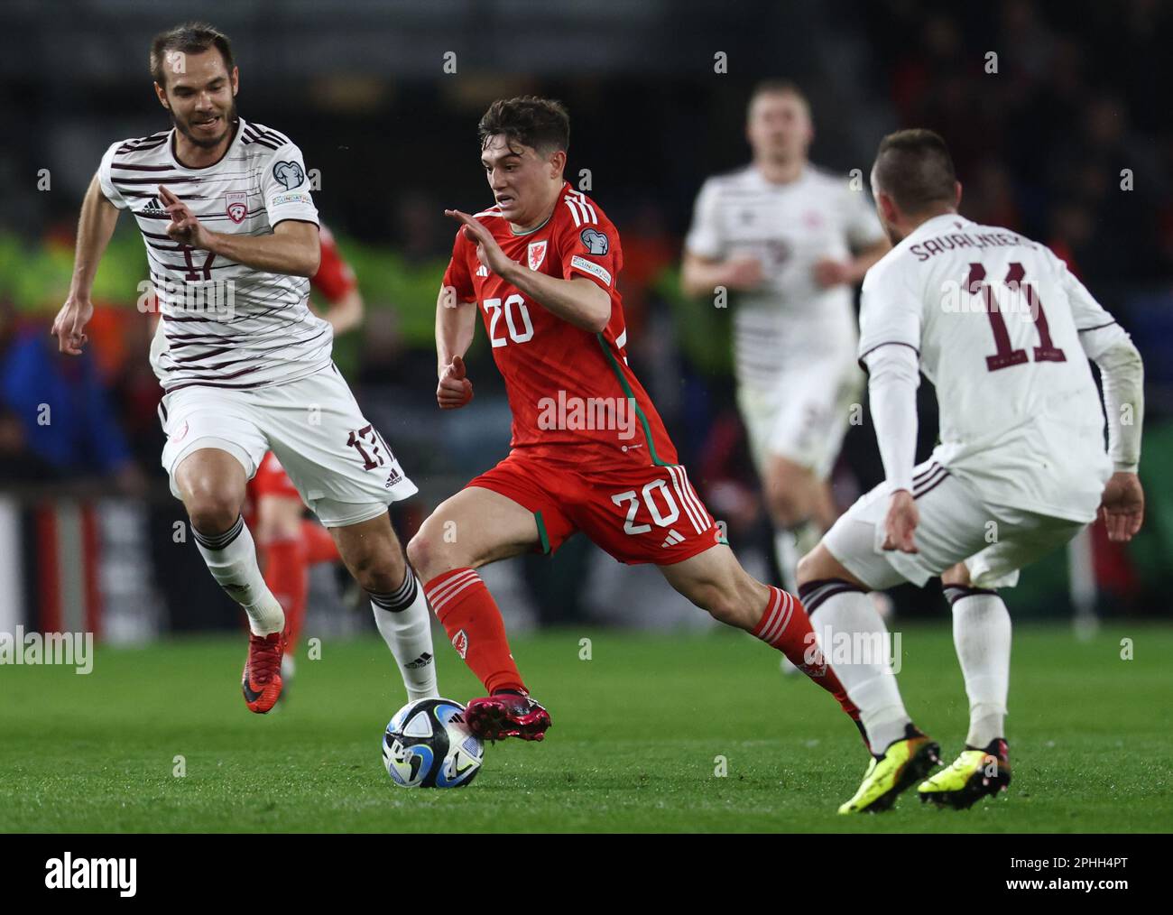 Cardiff, UK. 28th Mar, 2023. Daniel James of Wales sprints between the Latvians players during the UEFA European Championship Qualifying match at the Cardiff City Stadium, Cardiff. Picture credit should read: Darren Staples/Sportimage Credit: Sportimage/Alamy Live News Stock Photo