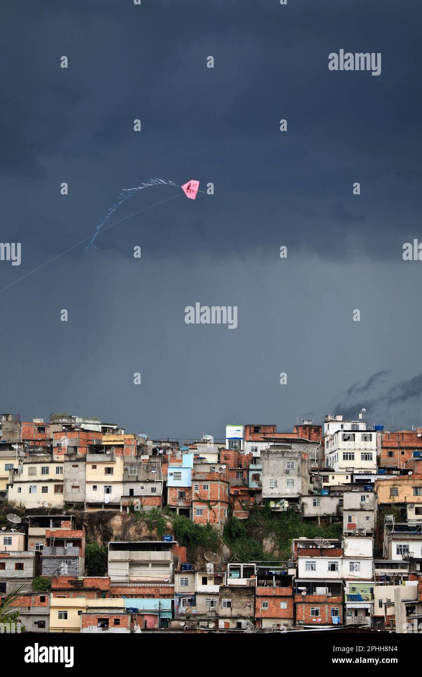 Kite flies over Morro do Timbau, one of the communities forming Favela da Maré, one of the largest slum complexes in Rio de Janeiro, a consequence of the low indicators of social development that characterize the north region of the city. Stock Photo