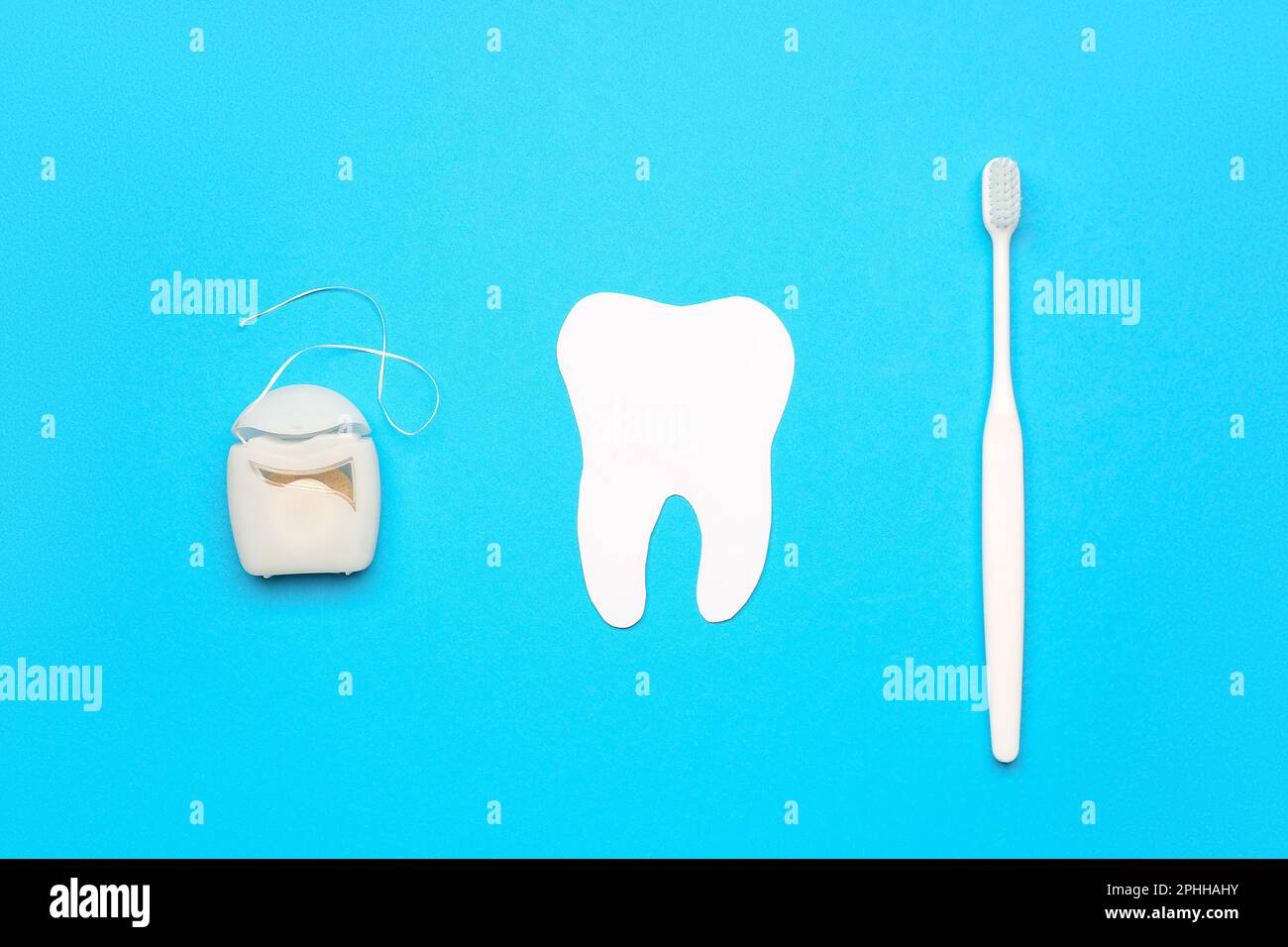 Dental floss, model of tooth and brush on blue background Stock Photo ...