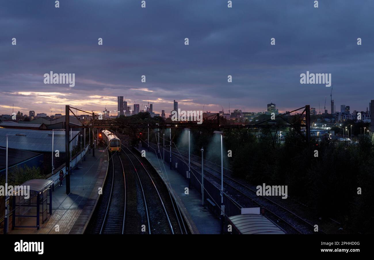 Ashburys railway station is in Manchester, the Manchester-Glossop  train line with the citys skyline of Manchester and the new towers of the city Stock Photo