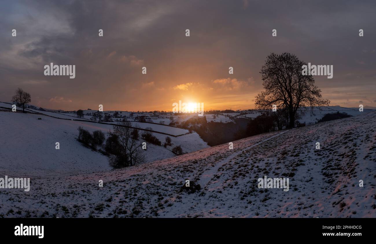 The Staffordshire landscape at sunset on a winters day with snow covering with farmland and fields close to the Manifold Valley Stock Photo