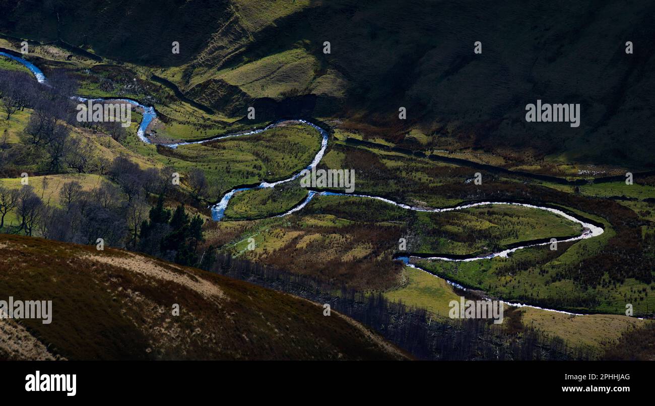 River Alport as it reflects the blue sky and meanders it's way down the valley. Large bends, and horseshoe-like loops caused by deposition and erosion Stock Photo